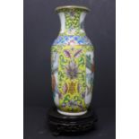 A 20th century Chinese vase, polychrome decorated with panels of figures in courtyard scenes, on a