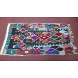 A Moroccan Berber Azilal rug, multi-coloured diamond design on a black ground, 220 x 110cm