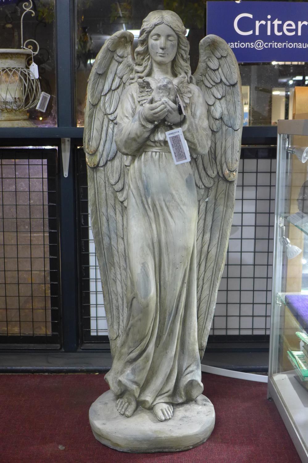 A cast plaster angel holding a bird, H.121cm