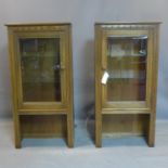 A pair of mid century Ercol teak cabinets, having bevelled glass glazed doors, bearing label, H.