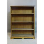 An Edwardian mahogany open bookcase, with ebonised edges, raised on pedestal base and bracket feet