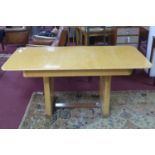 An Art Deco burr walnut extendable dining table with extra leaf, on stepped bracket feet, with glass