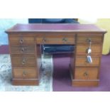 A Victorian pedestal desk with leather skiver, having an arrangement of nine drawers, on pedestal