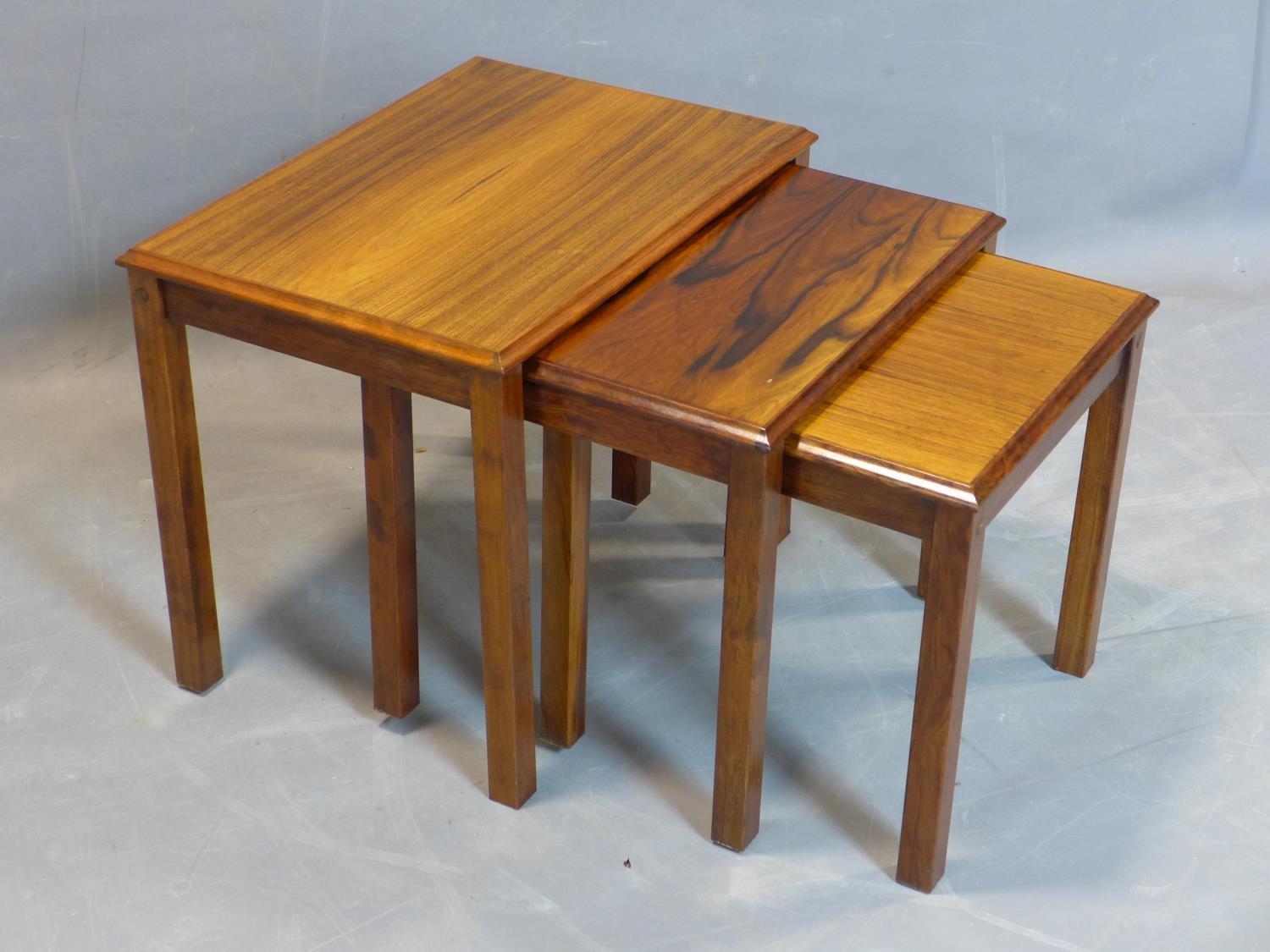 A nest of three Danish exotic hardwood tables, marked 'Made in Denmark' to bases, H.46 W.54 D.39cm