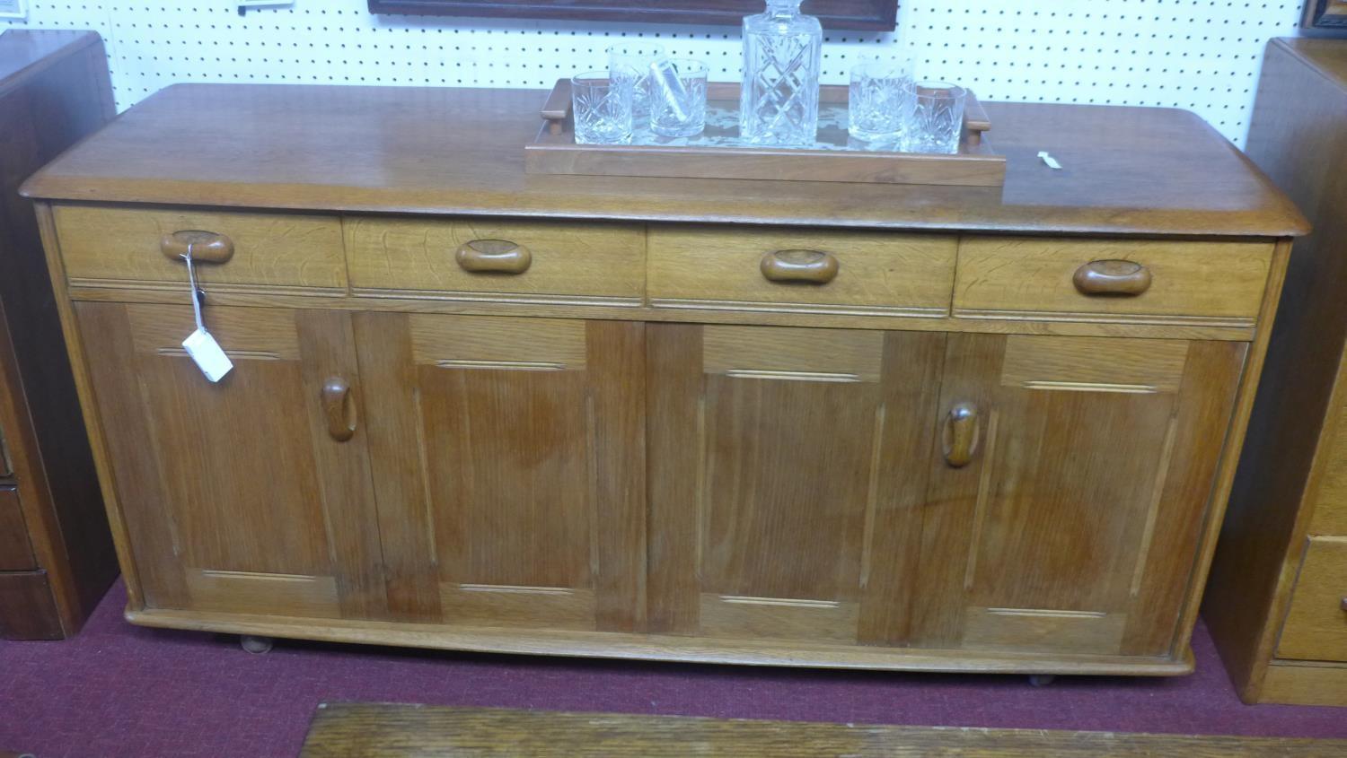 A mid 20th century Ercol teak sideboard, with four short drawers and two pairs of double doors, on
