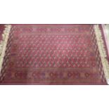 A Turkoman carpet with repeating gul motifs on a red ground, within geometric border and bands,