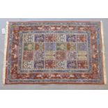 A Persian rug with repeating tile design with stylised floral motifs, within border with flowers,