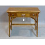 An Arts and Crafts oak side table, with central drawer, raised on square legs joined by