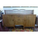 A mid 20th century walnut sideboard, having gallery back above three central drawers flanked by