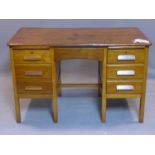 An early 20th century oak desk, having six drawers flanking central short drawer, on square legs,