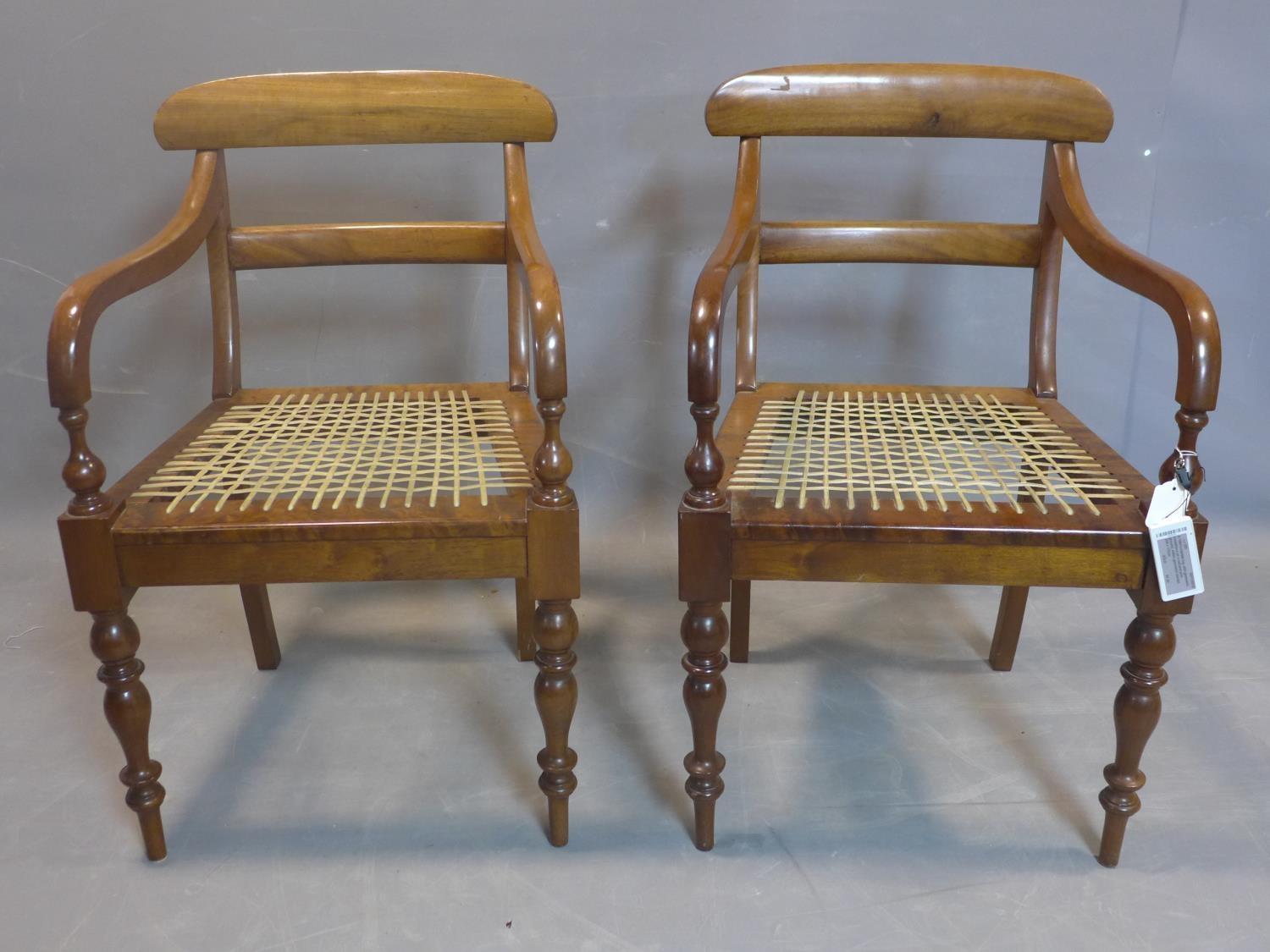 A pair of 19th century mahogany scroll armchairs, on turned baluster supports, having hide cord