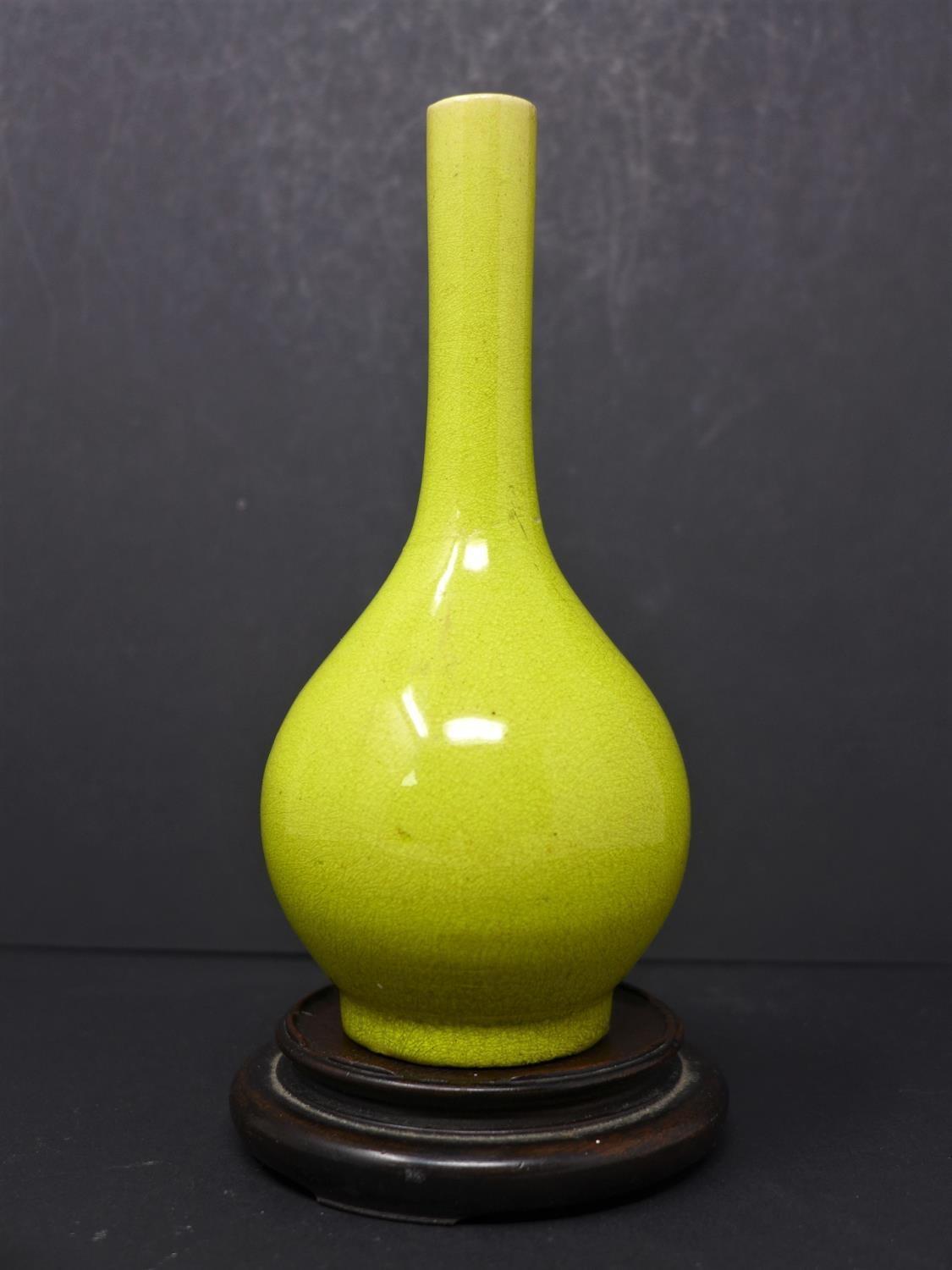 A Chinese late Ming lemon-yellow glazed ceramic bottle vase, with long neck and pronounced foot ring