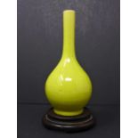 A Chinese late Ming lemon-yellow glazed ceramic bottle vase, with long neck and pronounced foot ring