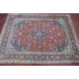 A Persian Kashan carpet, central floral medallion and stylised floral motifs on a rouge field,