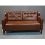 A brown leather 2 seater sofa, with button back cushions, on tapered legs, H.80 W.153 D.73cm, wear