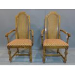 A pair of fruitwood and rattan carver armchairs, with caned backs, raised on turned legs joined by