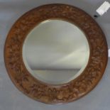 A 20th century circular mirror decorated with a oak festoons, diameter 50cm
