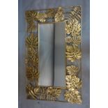 A rectangular framed mirror with gild metal floral border