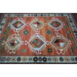 A vintage West German carpet, geometric and floral medallions on a orange, pink and light brown