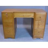 An Art Deco oak desk, with central long drawer flanked by six short drawers, on bracket feet, H.74