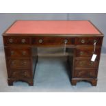 A Georgian style mahogany pedestal desk with an arrangement of nine drawers