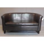 A two seater faux leather sofa, on tapered block feet, H.75 W.142 D.70cm