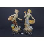 A pair of porcelain figures of a boy and a girl on marble bases, 1960's