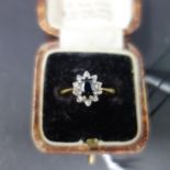 A 13ct gold, diamond and sapphire set ring of floral design, marked 13ct, with central oval cut