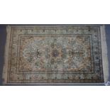 A Persian pure silk Herek rug, central floral medallion with stylised floral motifs on an ivory