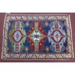 A Russian Shirvan rug, triple geometric medallions and floral motifs on a blue ground, within