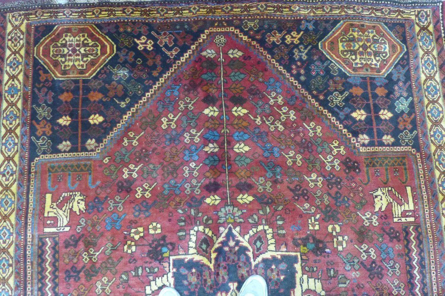 A Persian Qashqai carpet, central floral medallion and stylised petal motifs on a rouge field, - Image 4 of 5