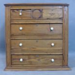 A pine table top chest, with two short over two long drawers, having ceramic handles (one