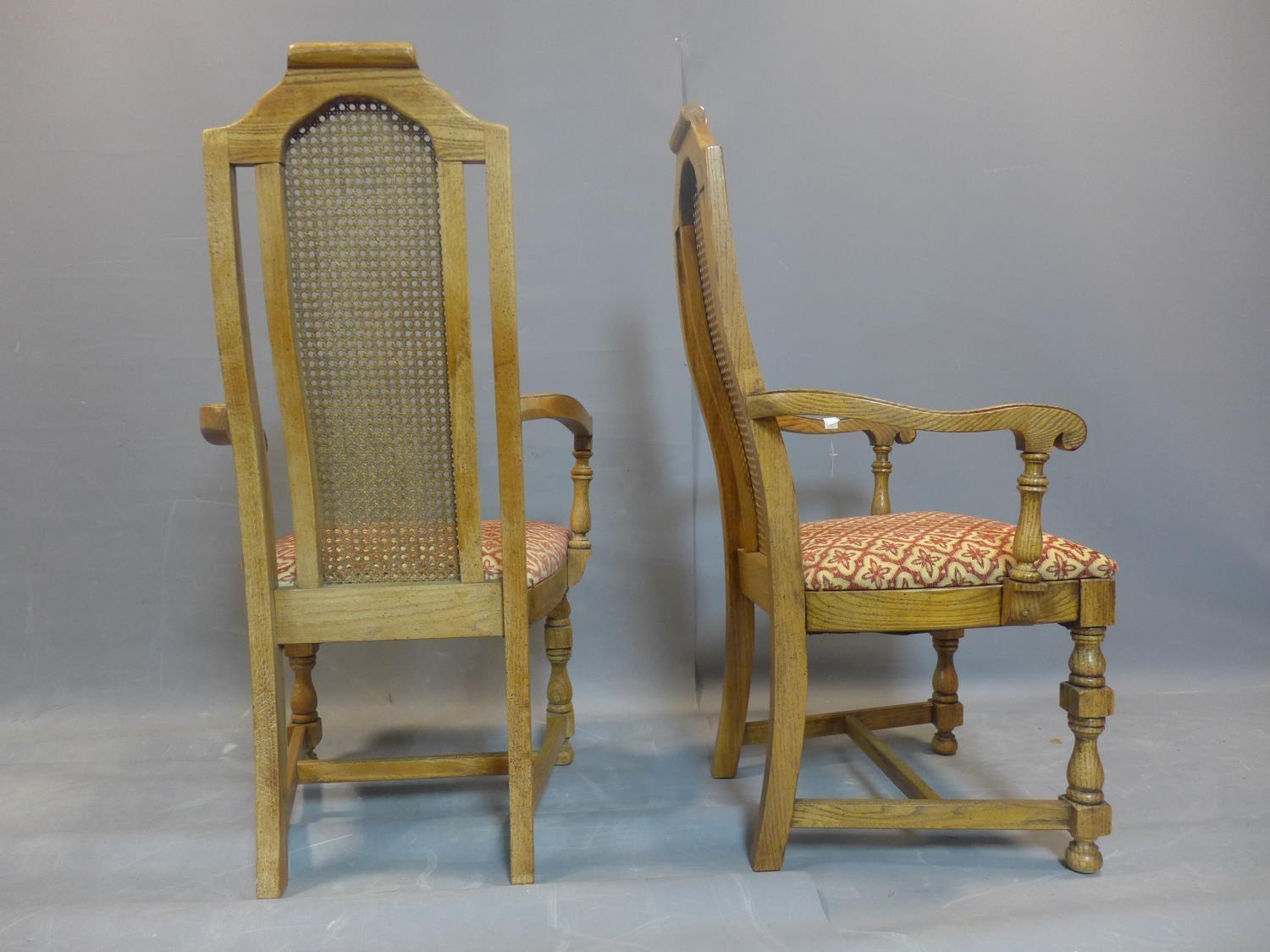 A pair of fruitwood and rattan carver armchairs, with caned backs, raised on turned legs joined by - Image 3 of 3