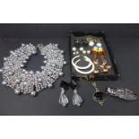 An ornate beaded necklace and a box of earrings, brooch, necklace etc
