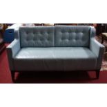 A light blue leather 2 seater sofa, with button back cushions, on tapered legs, H.80 W.153 D.73cm