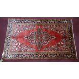 A North West Persian Lillihan rug, central double pendant medallion on a rouge field, within