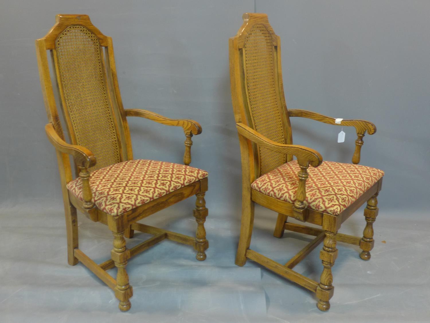 A pair of fruitwood and rattan carver armchairs, with caned backs, raised on turned legs joined by - Image 2 of 3
