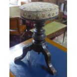 A Victorian mahogany parlour piano stool, dark oak carved with a tapestry seat.