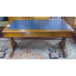 A 19th century mahogany library table, with scrolling supports, having blue leather skiver above two