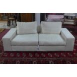 A contemporary two seater sofa with cream upholstery, with four cushions, H.60 L.202 D.98cm