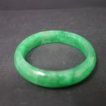 A Chinese green jadeite bangle, internal diameter 5.7cm