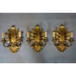 Three gilded wall lights with leaves motives