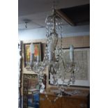 A six branch chandelier, with glass droplets and floral glass sconces, H.80cm Diameter 55cm