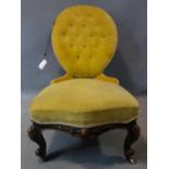 A Victorian mahogany spoon back nursing chair, button back yellow velvet upholstery, on carved