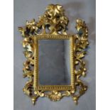 A Rococo style gilt wood and gesso mirror, the rectangular glass plate within beeded border, the