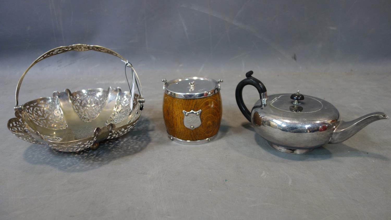 A group of silver plate items including a tea pot, a fruit basket and an ice bucket