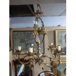 A Rococo style five branch gilt metal chandelier, with scrolling supports and central cherub, H.50