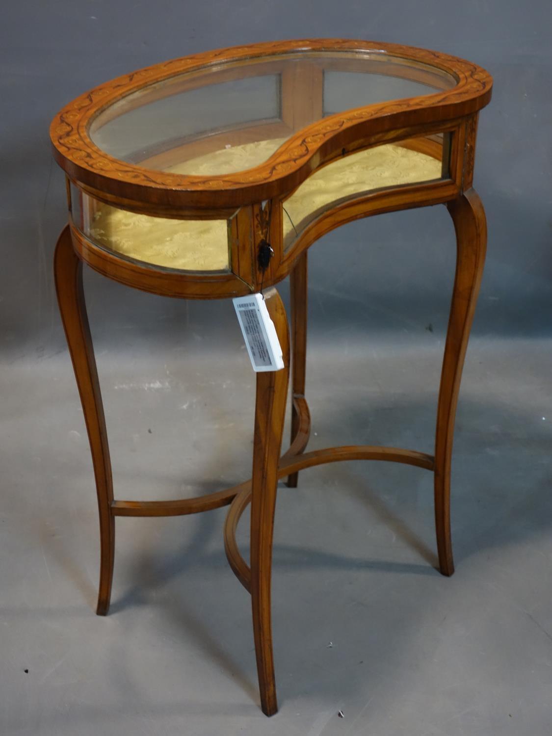 A 19th century inlaid satin wood kidney shaped bijouterie cabinet, raised on splayed legs joined