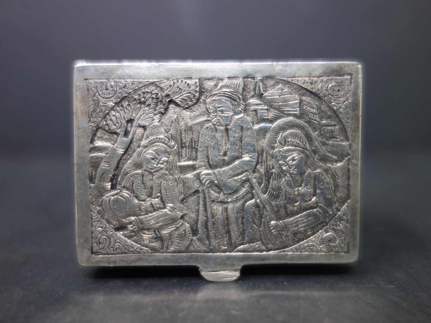 A Persian silver box, decorated with three figures and flowers, H.2 W.5.1 D.4cm, approx. 65g