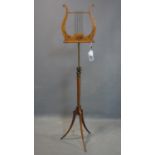 A Regency satinwood adjustable lyre shaped music stand, hand-painted with floral swags, on hexagonal